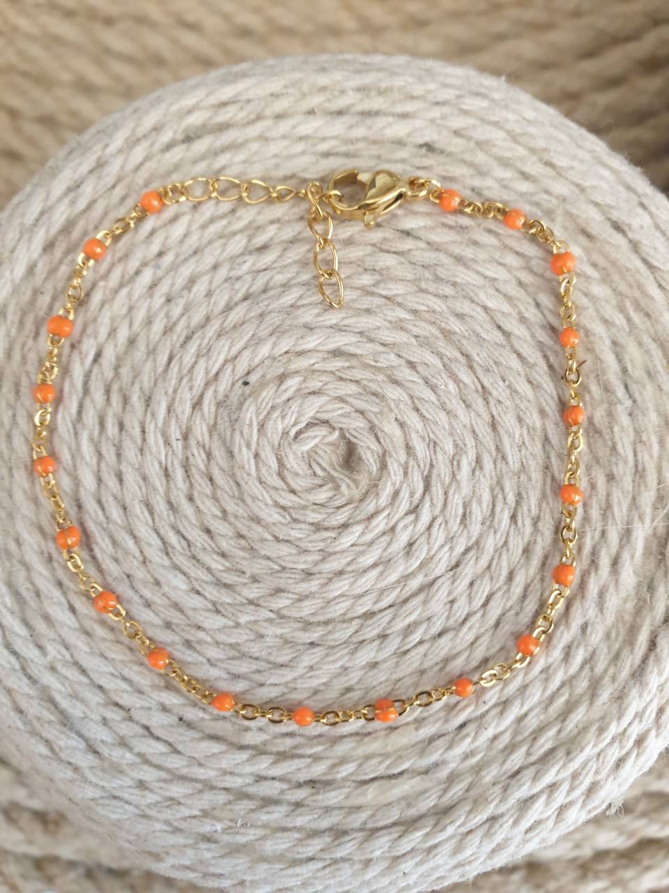 Création de bracelet en acier inoxydable  avec perles émaillées orange, fermoir mousqueton Adaptable à tous les poignets grâce à sa chaînette réglable