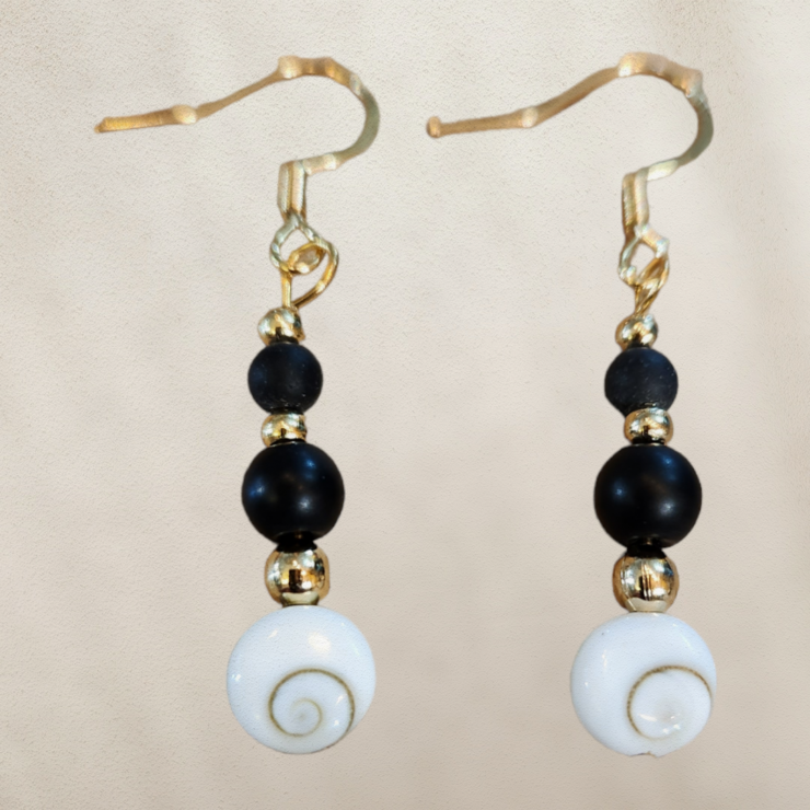 Boucles d'oreilles onyx noire perles véritable, petites perles acier inoxydable doré puis orné d'un opercule appelé l'œil de sainte Lucie, porte bonheur  Confectionné à la main,  